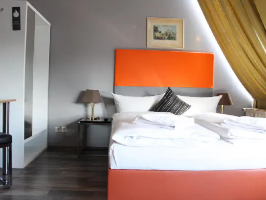 Zimmer mit orangefarbenem Kopfteil