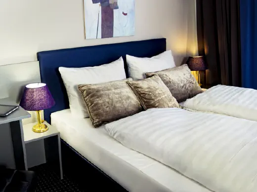 Zimmer mit weißen Bettbezügen