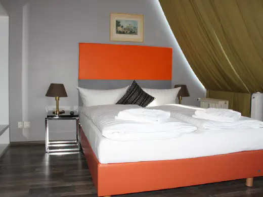 Bett mit orangefarbenem Kopfteil