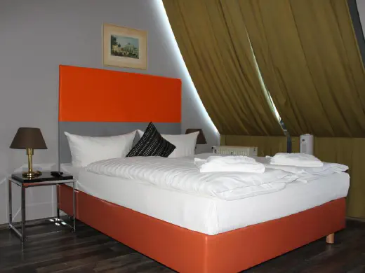 Zimmer mit violetter Tagesdecke